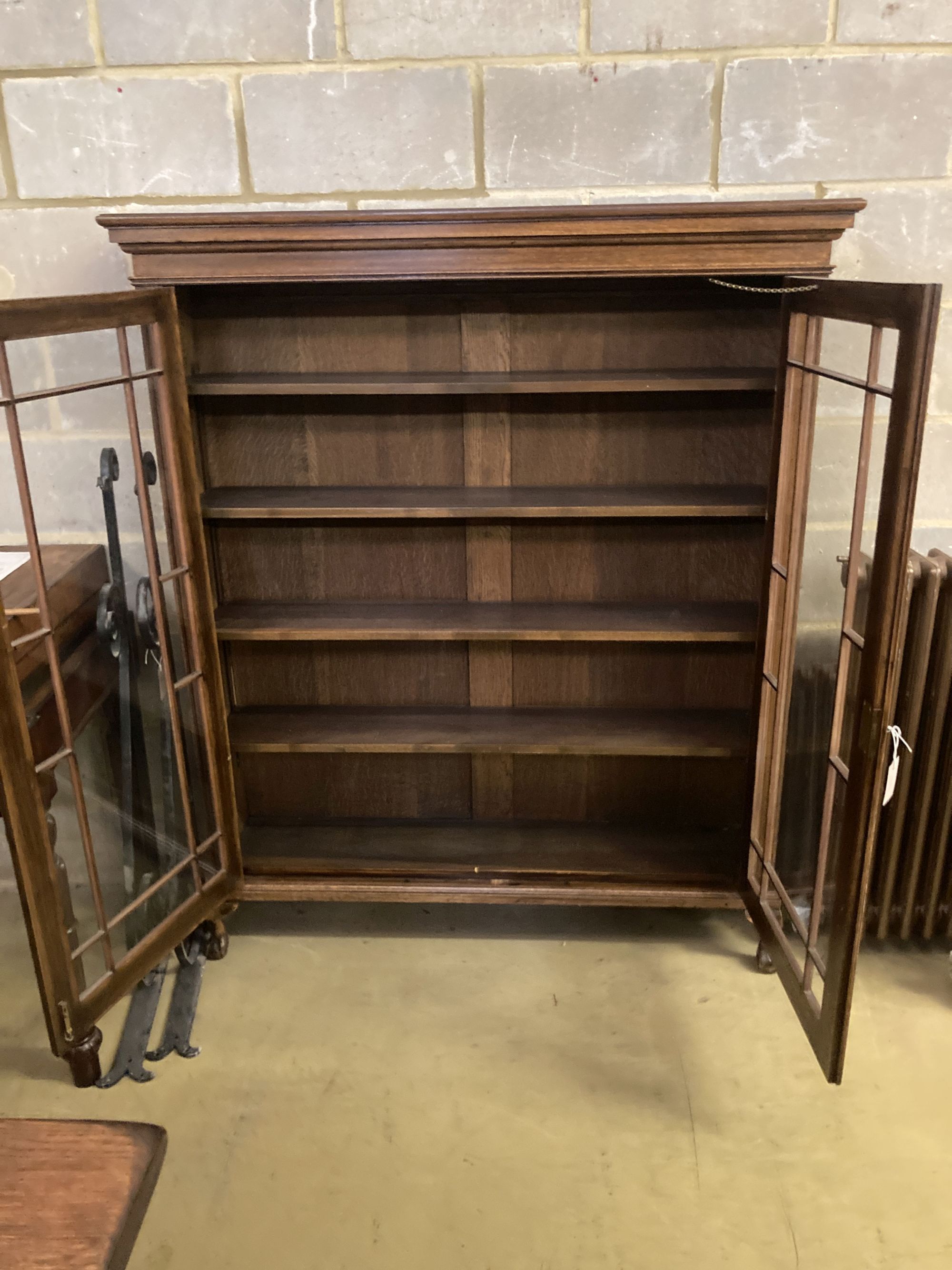 A 1920s glazed oak two door bookcase, length 130cm, depth 29cm, height 156cm